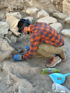 HKU archaeology PhD candidate Mr Hayk Azizbekyan digging on-site while wearing an MR headset and viewing the real world and the previously recorded 3D data. (Photo credit: HKU Faculty of Arts)
 